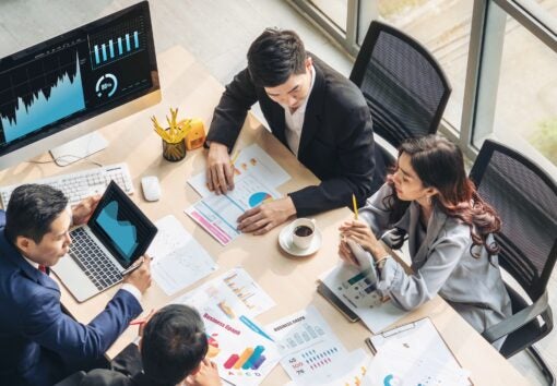 Office workers sitting at table with coffee