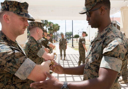 A U.S. Marine with Special Purpose Marine Air-Ground Task Force-Crisis Response-Africa 19.2, Marine Forces Europe and Africa, instructs a student on a proper draw technique of noncommissioned officer sword during Corporals Course at the Naval Air Station Sigonella, Sicily, Italy, July 17, 2019. The Marines and a Sailor with SPMAGTF-CR-AF 19.2 participated in the course that consisted of classes on land navigation, sword and guidon manual, and development of mentorship and leadership skills. SPMAGTF-CR-AF is deployed to conduct crisis-response and theater-security operations in Africa and promote regional stability by conducting military-to-military training exercises throughout Europe and Africa. (U.S. Marine Corps photo by Staff Sgt. Mark E. Morrow Jr.)