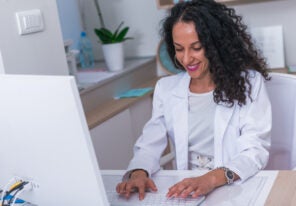 Portrait of a medical worker typing a medical report on her computer in the lobby.