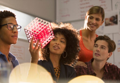 Creative young business people examining prototype in meeting