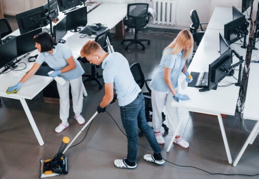 Concentrated at job. Group of workers clean modern office together at daytime.