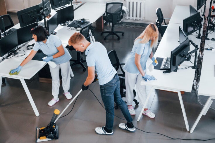 Concentrated at job. Group of workers clean modern office together at daytime.