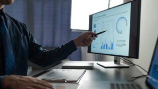 Businessman analyzing financial data statistics on pc computer pointing at screen with graph Chart showing company growth using easy accounting software to plan. Management for start-up business.