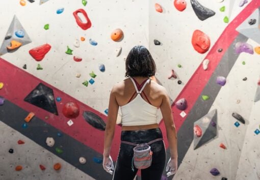 woman ready for practice rock climbing on artificial wall indoors. Active lifestyle and bouldering concept.