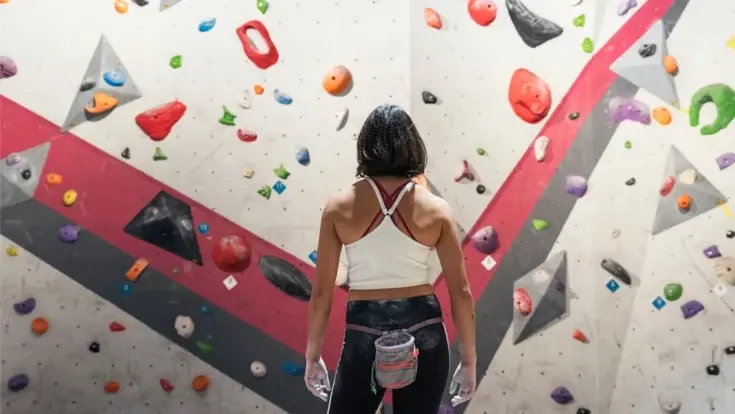 woman ready for practice rock climbing on artificial wall indoors. Active lifestyle and bouldering concept.