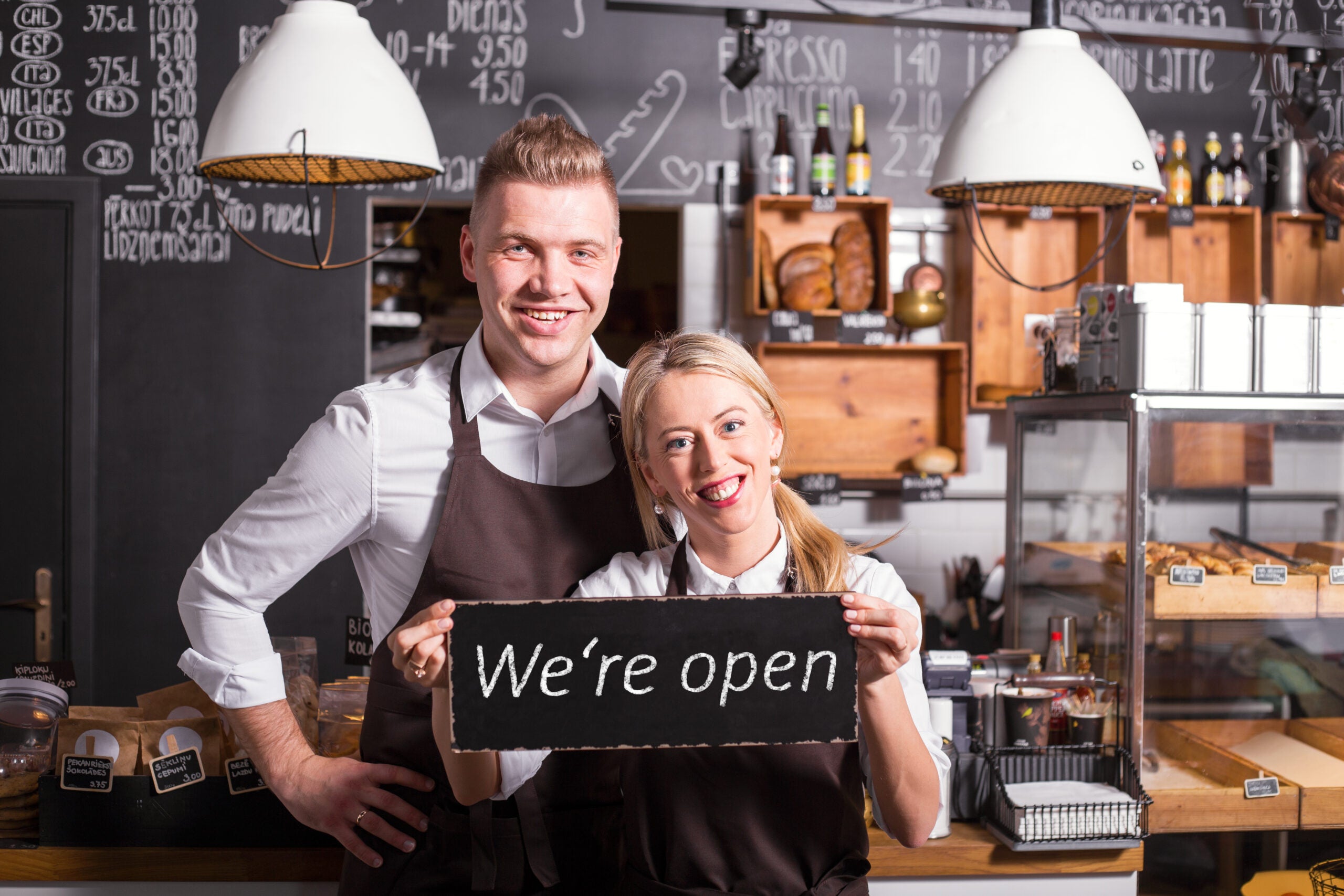 Coffee shop owners showing open sign