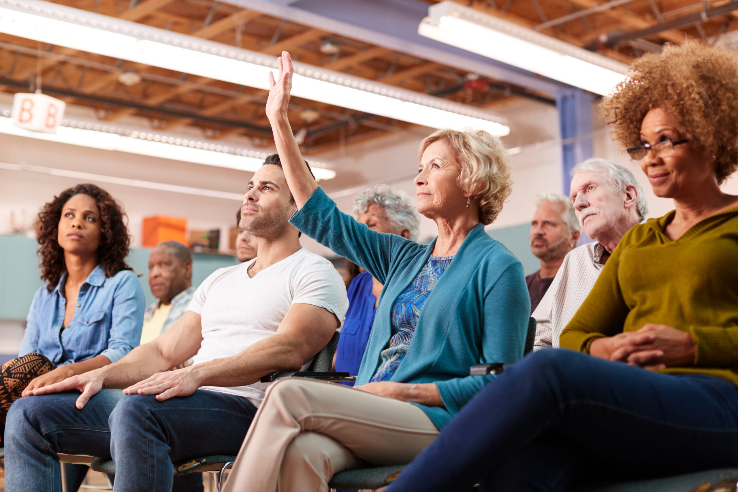 Woman Asking Question At Neighborhood Meeting In Community Center