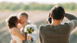 wedding photographer takes pictures of the bride and groom in nature in autumn, the photographer in action