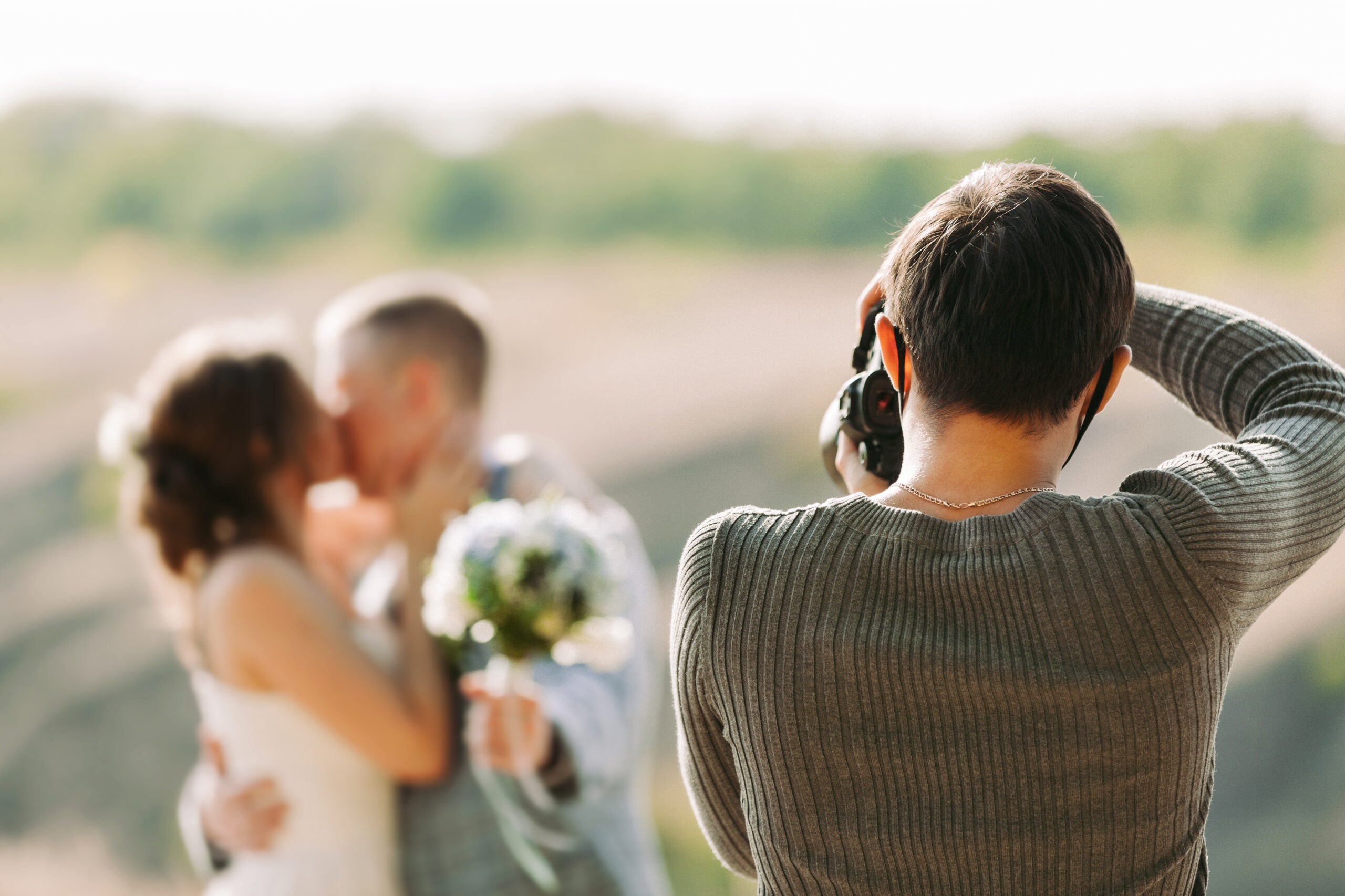 wedding photographer takes pictures of the bride and groom in nature in autumn, the photographer in action