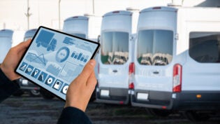 Manager with a digital tablet on the background of trucks. Fleet management