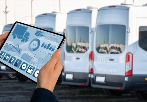 Manager with a digital tablet on the background of trucks. Fleet management