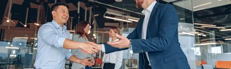 Men are shaking their hands in modern office