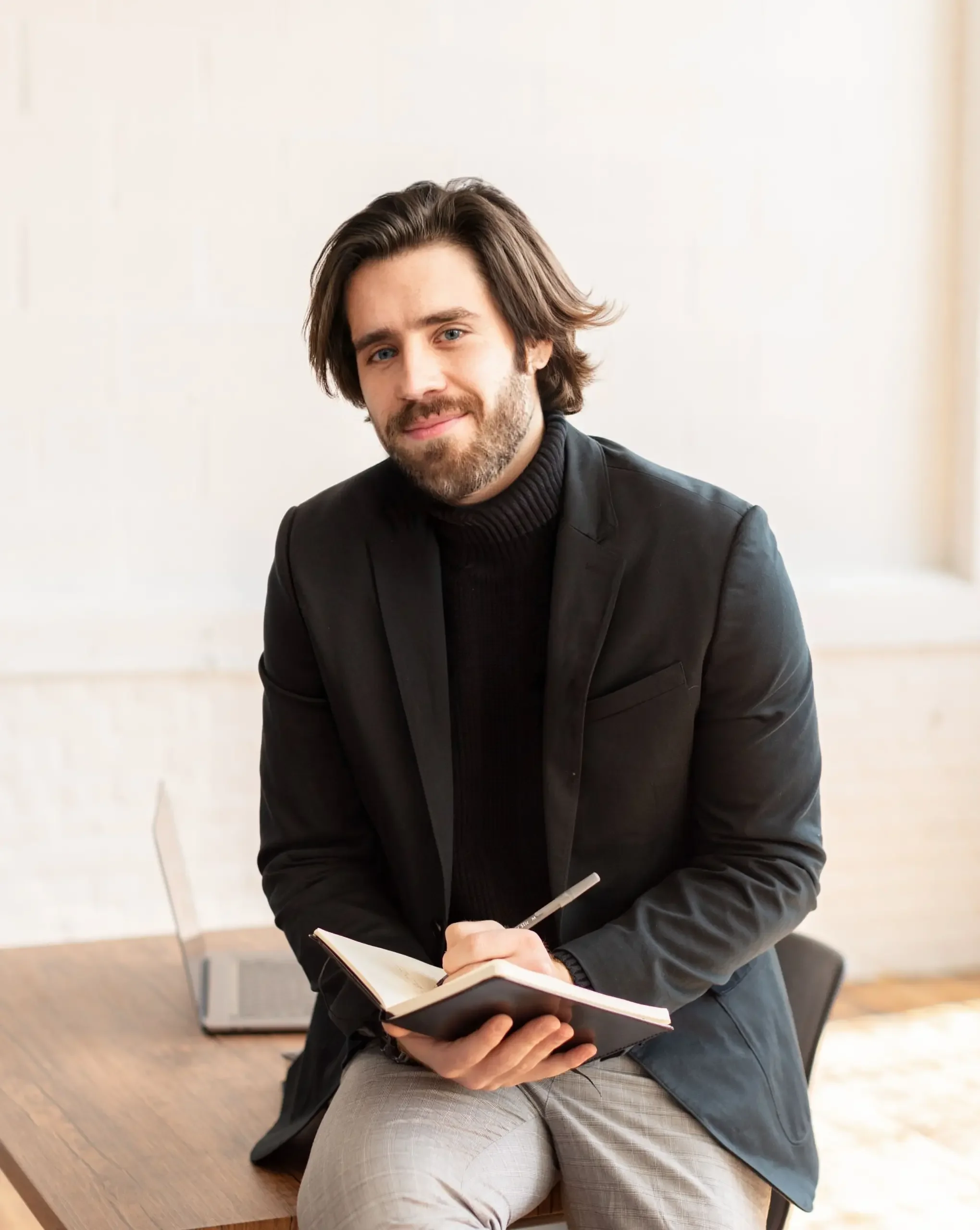 Young man with beard writing in journal