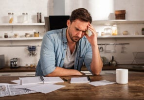 Man at his desk showing problems with bills. Concept of economic failure