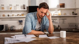 Man at his desk showing problems with bills. Concept of economic failure