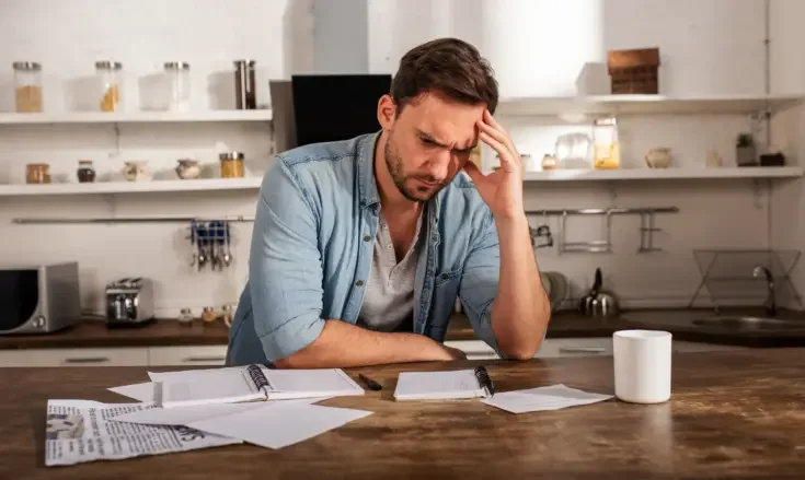 Man at his desk showing problems with bills. Concept of economic failure