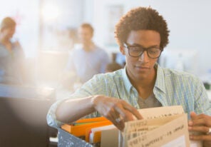 Young creative businessman looking at files in office