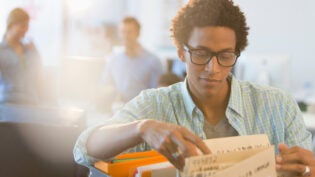 Young creative businessman looking at files in office