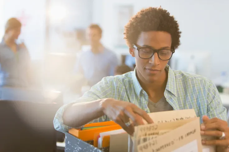 Young creative businessman looking at files in office