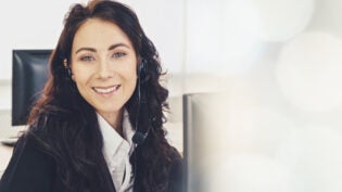 Business woman wearing headset working in office broaden view