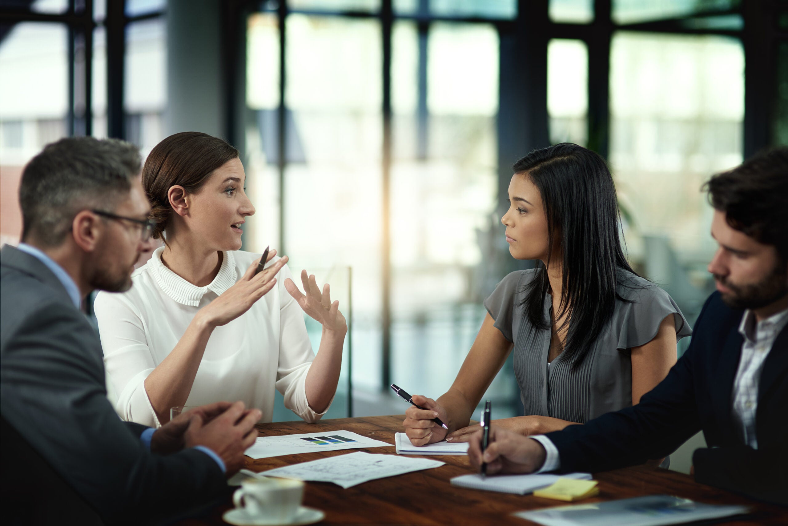 Business people, conversation and paperwork in meeting for strategy on international growth, network expansion and benchmarking. Corporate, teamwork and talk for collaboration, planning and research.