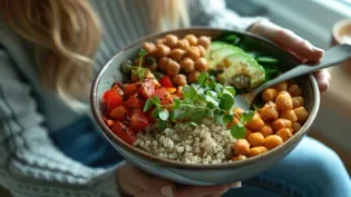 Close up view of a woman enjoying a nutritious and colorful Buddha bowl filled with quinoa chickpeas roasted vegetables and fresh greens The vibrant dish represents a balanced healthy