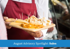 salesman holding cutting board with assorted cheese in store