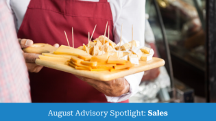 salesman holding cutting board with assorted cheese in store