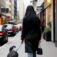 Woman walking dog in city