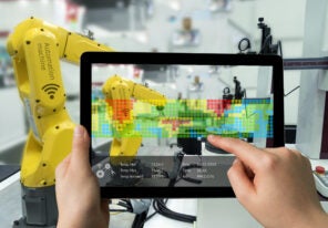 Man hand holding tablet with Augmented reality screen software and blue tone of automate wireless Robot arm in smart factory background