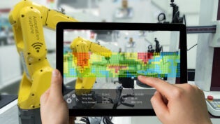 Man hand holding tablet with Augmented reality screen software and blue tone of automate wireless Robot arm in smart factory background