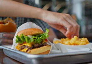 Woman eating burger in fast food restaurant