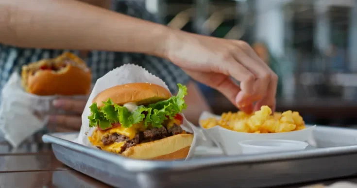 Woman eating burger in fast food restaurant