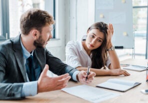 sad woman sitting with upset businessman in office