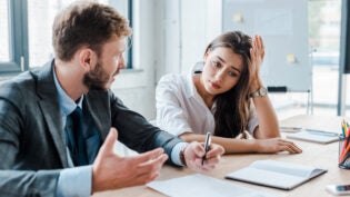 sad woman sitting with upset businessman in office