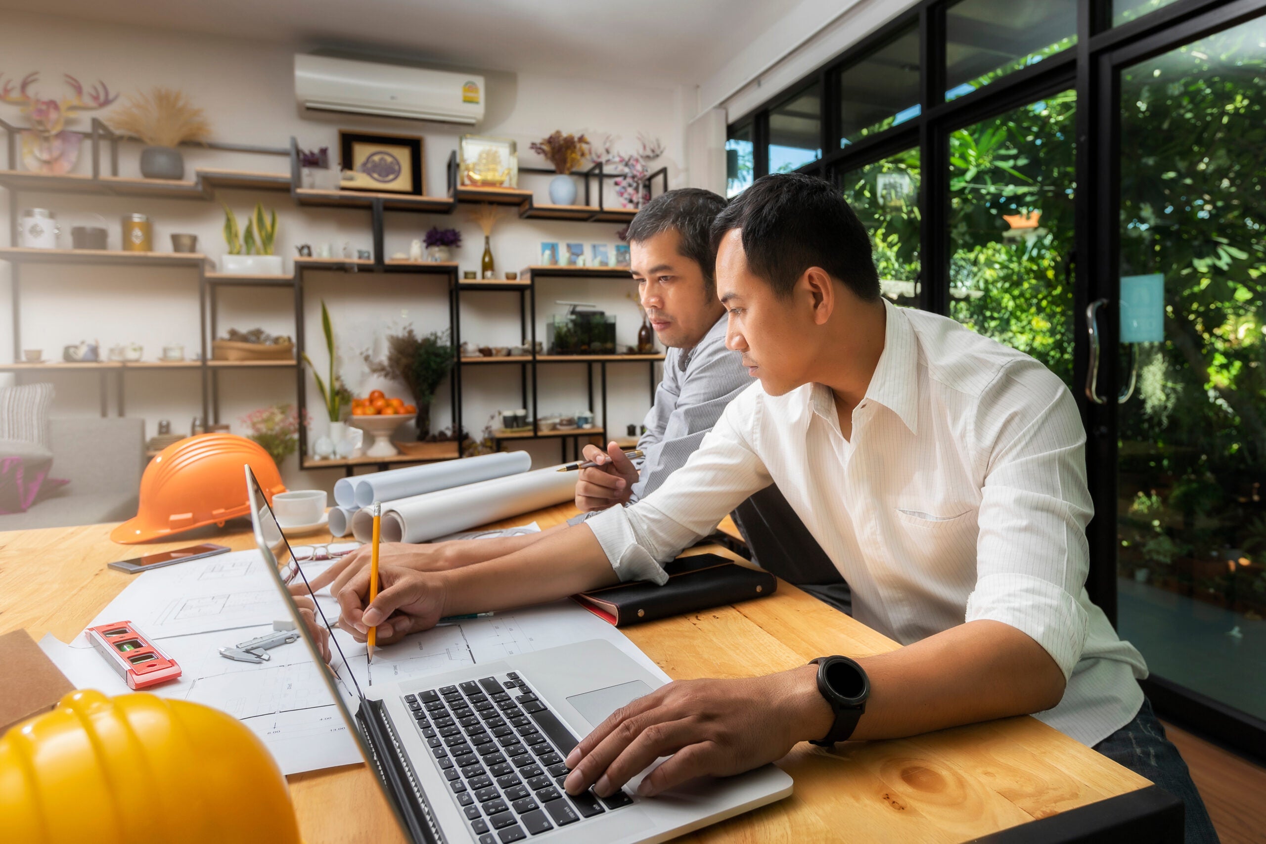 Confident team of architect working together in a office.They discussing about new startup project on desk. Architect discuss with engineer about project in office, architectural concept