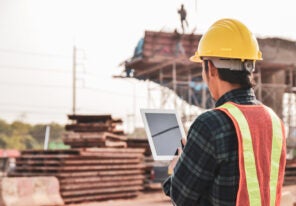 Construction engineers are using tablets to inspect construction projects on the background of the construction site.