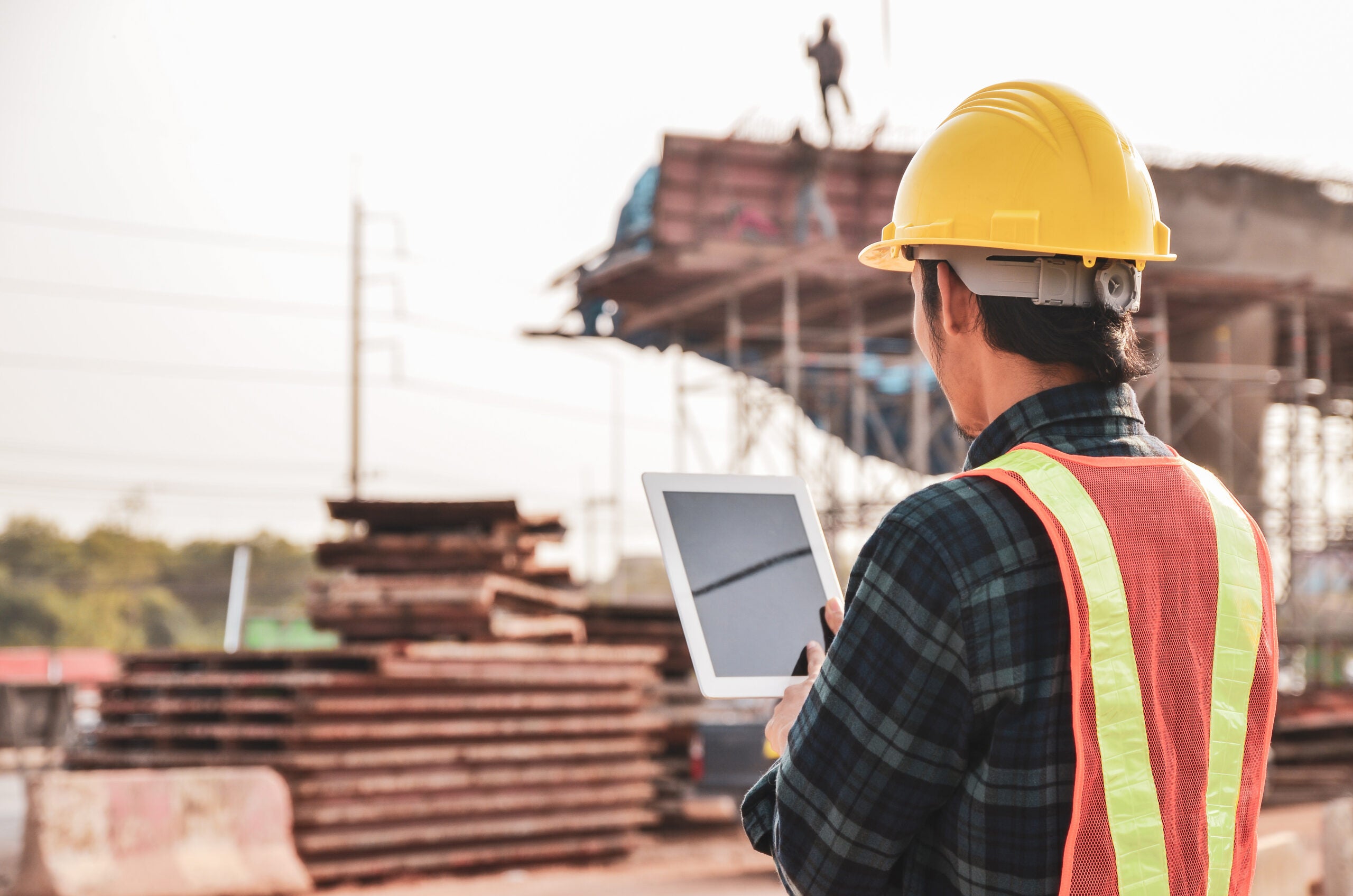 Construction engineers are using tablets to inspect construction projects on the background of the construction site.