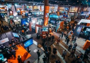 Group of attendees standing around a bustling convention hall at a tech conference or expo, showcasing innovation and excitement