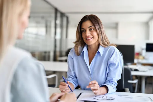 Women conversing over paperwork