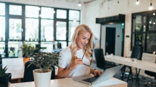 Successful female entrepreneur at work in modern open-space offi