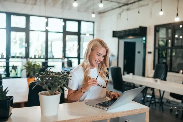 Successful female entrepreneur at work in modern open-space offi