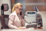 Young female receptionist talking on phone in office