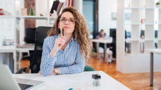 Thoughtful young businesswoman thinking of business problem solu