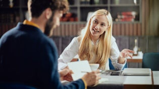 businesswoman dressed smart casual discussing with her male colleague