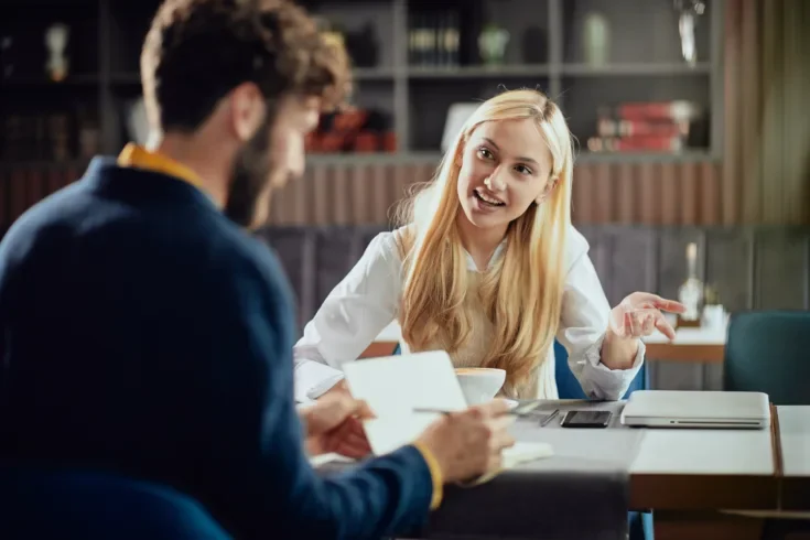 businesswoman dressed smart casual discussing with her male colleague