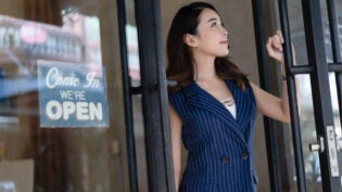 happy young owner small business standing at restaurant, cafe entrance door.