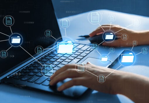 Businesswoman working on laptop with virtual screen.