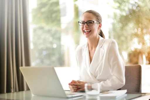 Business woman laughing while seated at desk