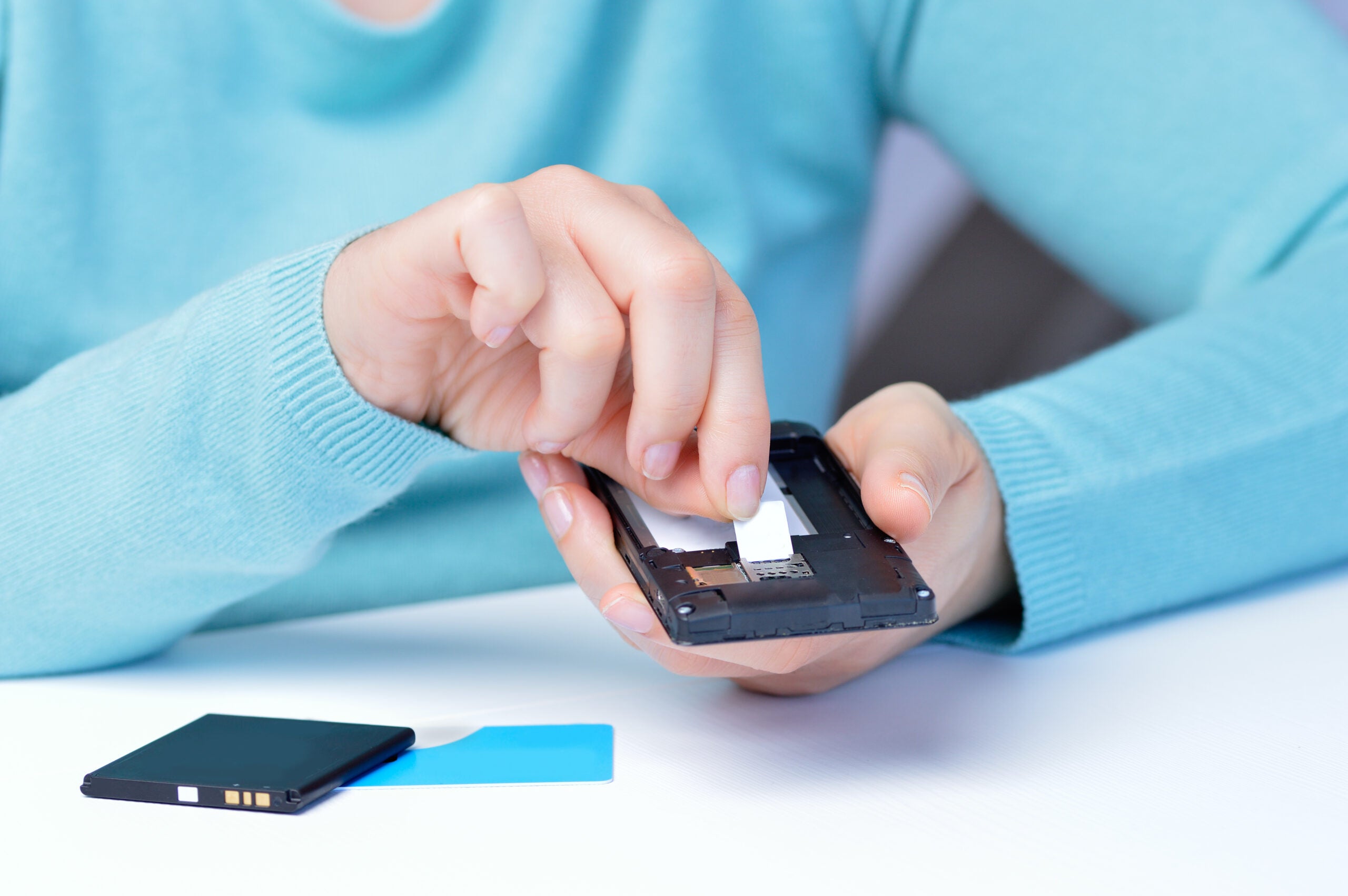 Woman hands putting the sim card on the phone